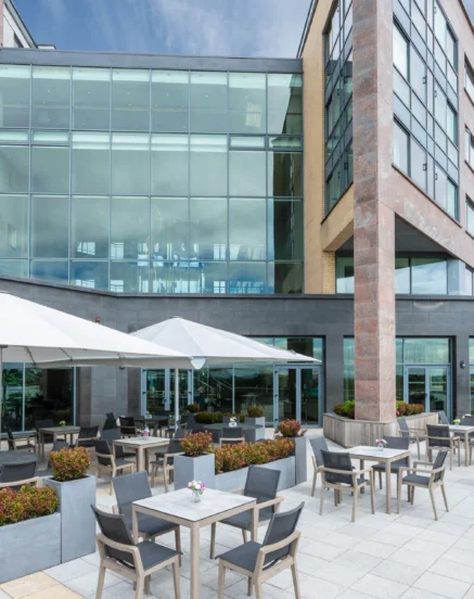 Relaxing outdoor dining area at The Galmont Hotel & Spa, with families enjoying sunny seating.