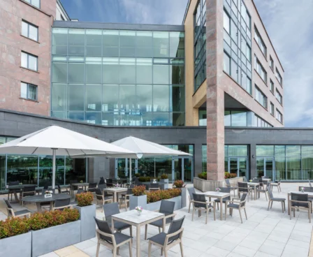 Relaxing outdoor dining area at The Galmont Hotel & Spa, with families enjoying sunny seating.