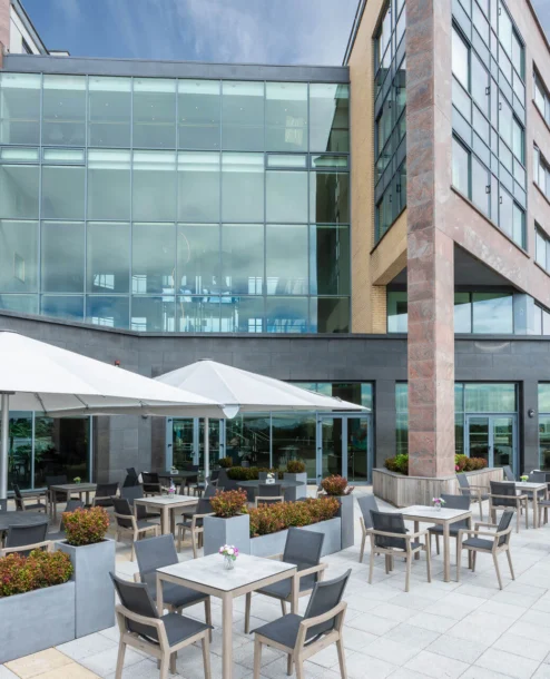 Relaxing outdoor dining area at The Galmont Hotel & Spa, with families enjoying sunny seating.
