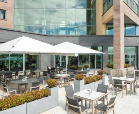 Outdoor patio with tables, chairs, and large umbrellas at The Galmont Hotel & Spa.