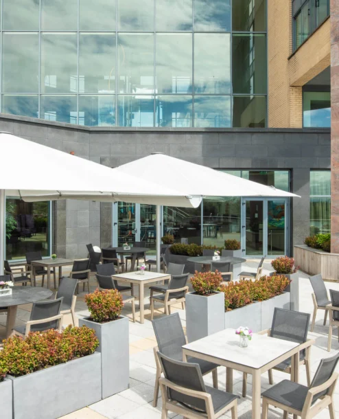 Outdoor patio with tables, chairs, and large umbrellas at The Galmont Hotel & Spa.