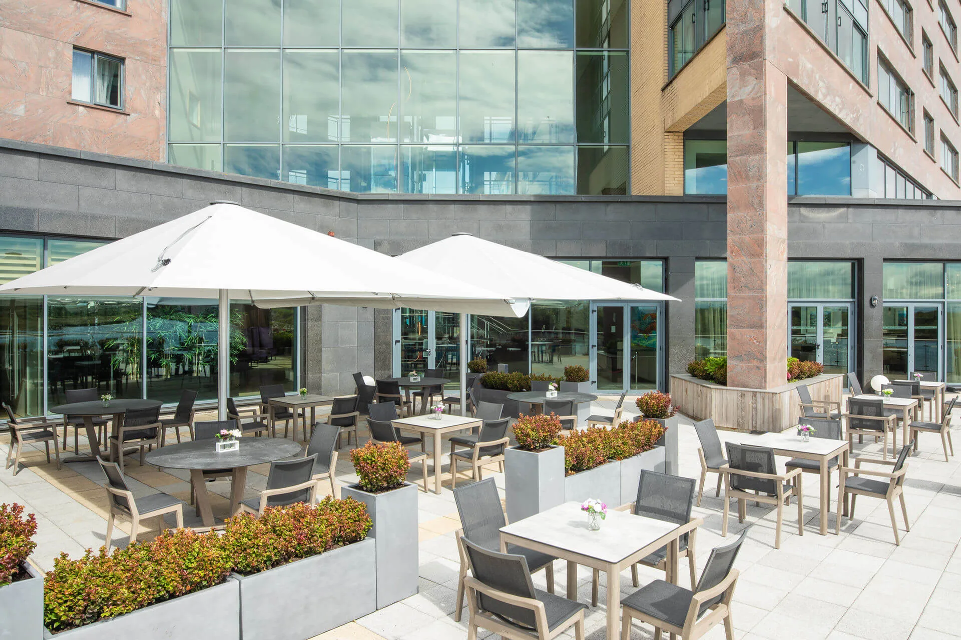 Outdoor patio with tables, chairs, and large umbrellas at The Galmont Hotel & Spa.