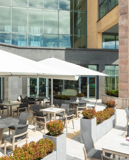 Outdoor dining area at The Galmont Hotel with tables, umbrellas, and modern decor.