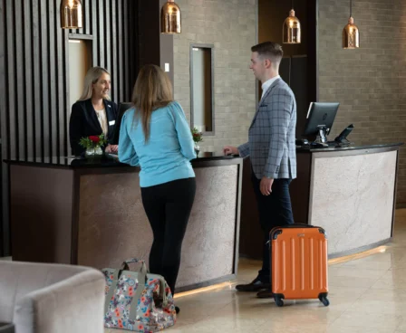 A couple checks into The Galmont Hotel at a welcoming front desk with modern decor.