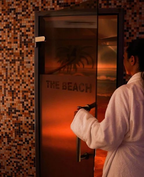 Guest in robe enters serene spa room at The Galmont Hotel.