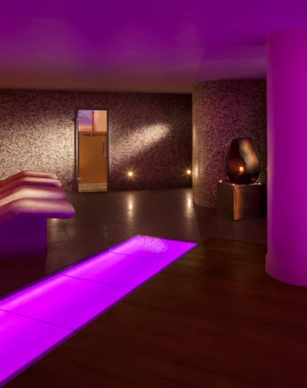 Relaxing spa area with cosy lounge chairs and soothing purple lighting at The Galmont Hotel.