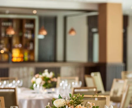 Elegant dining area with floral centrepieces and a shimmering chandelier at The Galmont Hotel.