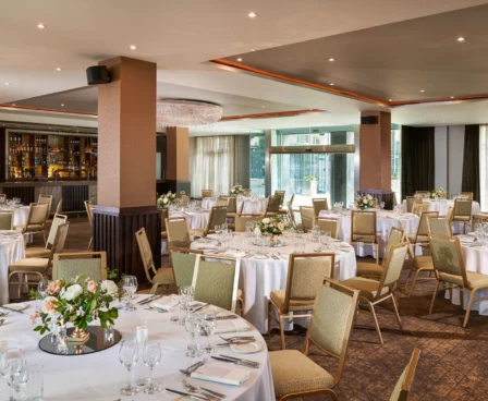 Elegant hotel dining room with round tables set for a group event.