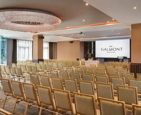 Spacious meeting room at The Galmont Hotel, set with rows of chairs and a large screen.