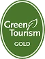 Green Tourism Gold award badge with leaf design.