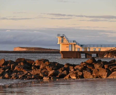 Family enjoying the beach near a diving platform at sunset by The Galmont Hotel & Spa.