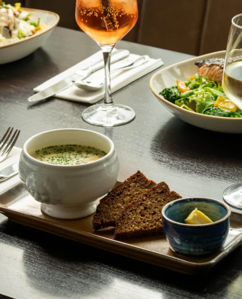 Elegant dining setup with soup, brown bread, and drinks at The Galmont Hotel & Spa.