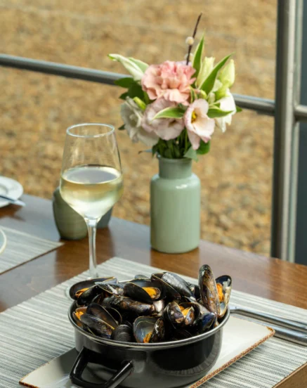 Elegant dining setup with mussels and wine at The Galmont Hotel & Spa, Galway.