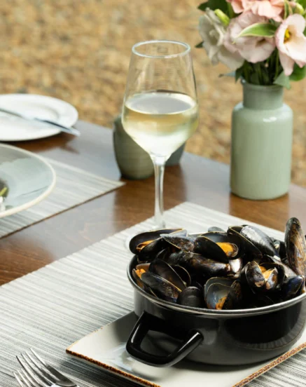 Elegant dining with mussels and wine at The Galmont Hotel, fresh flowers on table