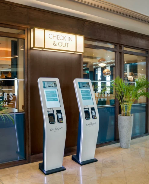Family checking into The Galmont Hotel with bright, inviting lobby and digital kiosks.