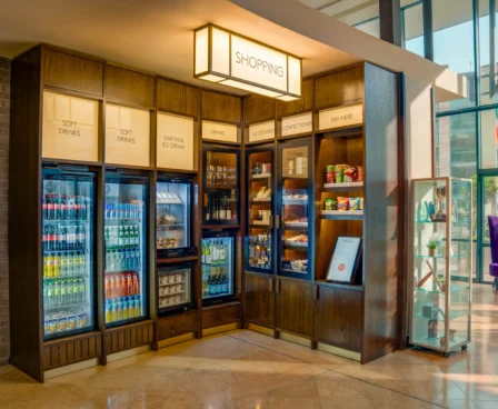Hotel shop with refreshments and snacks display, warm lighting, cosy atmosphere.