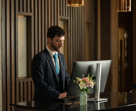 Reception staff member at The Galmont Hotel welcoming guests warmly.