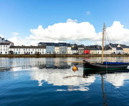 A peaceful harbour view at The Galmont Hotel & Spa with moored rowboat and quaint houses.