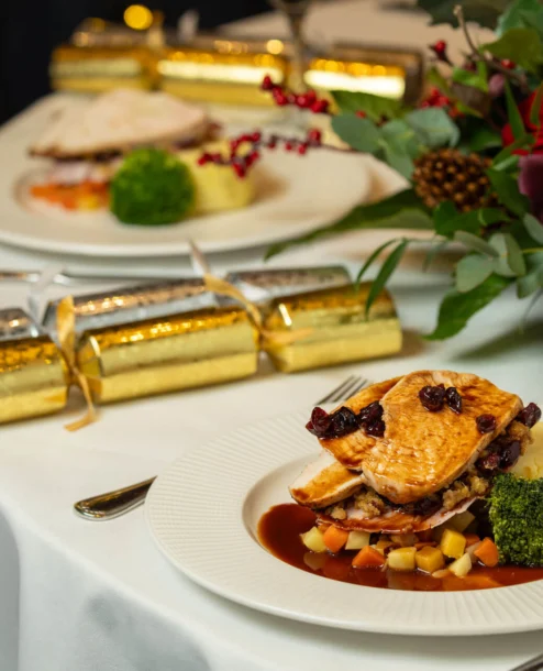 Elegant dining setup with gourmet dish at The Galmont Hotel & Spa, festive decor.