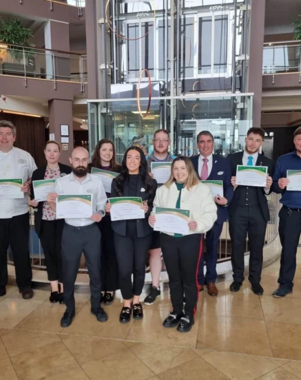 Team members proudly displaying certificates in The Galmont Hotel & Spa lobby.