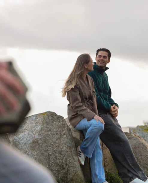 A couple enjoys a tranquil seaside view on rocks near The Galmont Hotel & Spa.