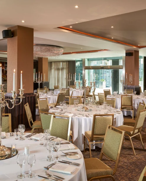 Elegant dining area at The Galmont, set for a family gathering with round tables and candelabras.
