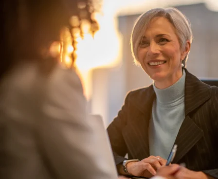 Warm welcome at The Galmont Hotel's bright lounge as two women engage in friendly conversation.