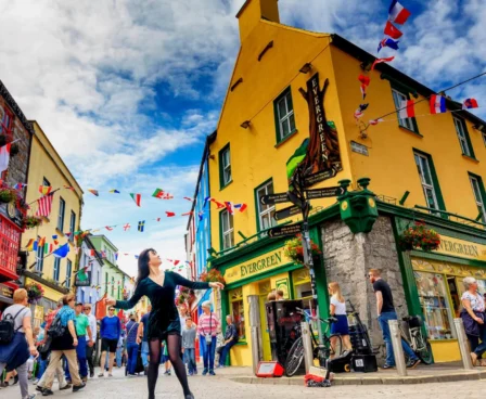 Vibrant street scene near The Galmont Hotel & Spa with families exploring shops under colourful flags.